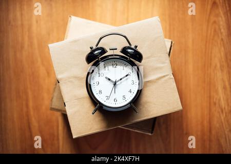 Same Day delivery Ship From Store. Faster Delivery. Many Cardboard boxes and black alarm clocks ready for delivery. Stock Photo