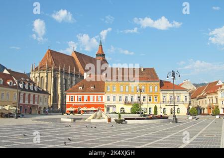 View across The Council Square (Piata Sfatului) towards 15th century Gothic Black Church (Biserica Neagră), Brasov old town, Transylvania, Romania Stock Photo