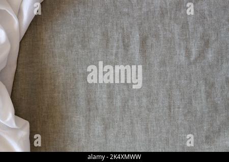 Abstract crumpled linen fabric texture background. Natural gray hue dyed linen and white color blend linen fabric background. Top view Stock Photo