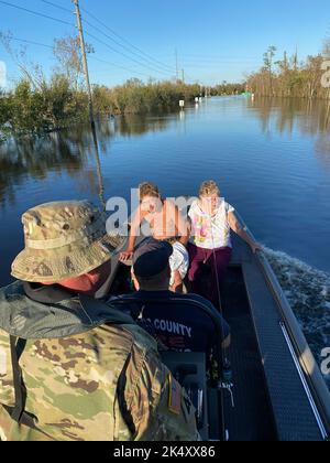 Florida National Guard Soldiers transport residents during Hurricane Ian relief efforts in Arcadia, Fla., Oct. 3, 2022. Florida National Guard's Chemical, Biological, Radiological/Nuclear, and Explosive (CBRNE) - Enhanced Response Force Package (FL-CERFP) conducted search and rescue operations alongside first responders through flooded areas across South West Florida. Hurricane Ian left many residents unable to evacuate their homes safely due to rising water. CERFP deployed all available ground and maritime vessels in support of continuous missions in order to ensure the safety of the communit Stock Photo