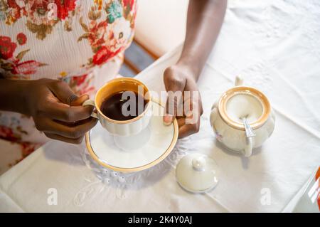 Young woman hands holding a vintage coffee cup. Using antique coffee set Stock Photo
