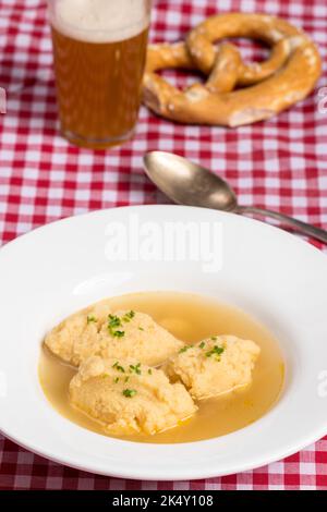 bavarian dumpling soup on tablecloth Stock Photo