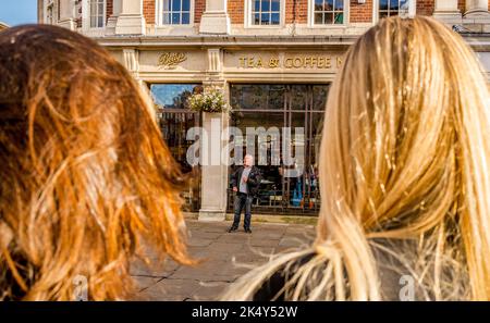 Male busker singing in the market square outside the famous Bettys tea room in York city center. Stock Photo