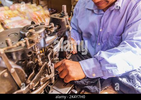 Thebes, Luxor, Egypt. Man repairing clothing with an old sewing machine. Stock Photo
