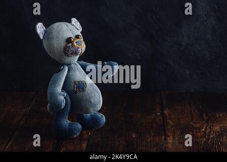 Close Up of Jeans Bear Toy Standing on Wooden Table Stock Photo