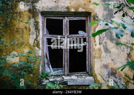 Broken window of shabby old house Stock Photo