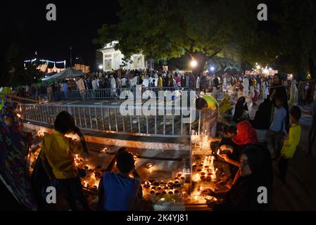 Lahore, Punjab, Pakistan. 4th Oct, 2022. Pakistani Muslim devotees light candles earthen oil lamps and devotees (Malang) dance at the shrine of famous fifteenth century Sufi Saint Hazrat Mir Mohammed Muayyinul during 399th URS birth anniversary celebrations in Lahore. Thousands of people across the country visit the shrine to pay tribute to him during a three-day festival. The saint was equally popular among the Muslim and Sikh religions, as Mian Mir went to Amritsar (India) in December 1588 to lay the foundation stone of Sikh's holiest site, the Golden Temple, which is commonly known as Sri Stock Photo