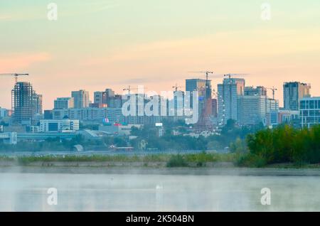 Novosibirsk, Siberia, Russia, 09.03.2022. Morning on the banks of the Ob. The embankment of the big city in the morning fog Stock Photo