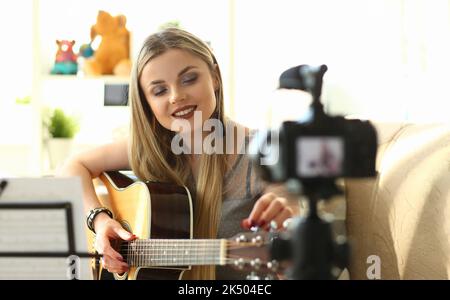 Young woman plays acoustic guitar and records video clips for social networks Stock Photo