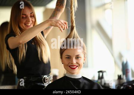 Professional female hairdresser stylist cuts hair of female client in salon Stock Photo
