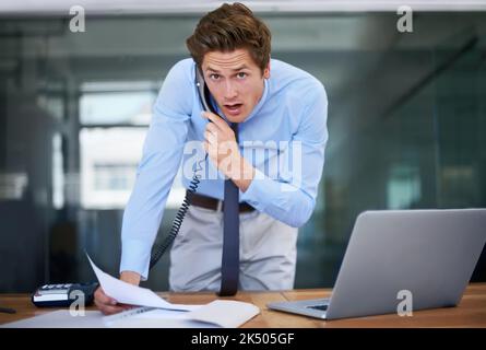 Could things get anymore hectic. A snowed-under businesswoman taking a call while holding paperwork. Stock Photo