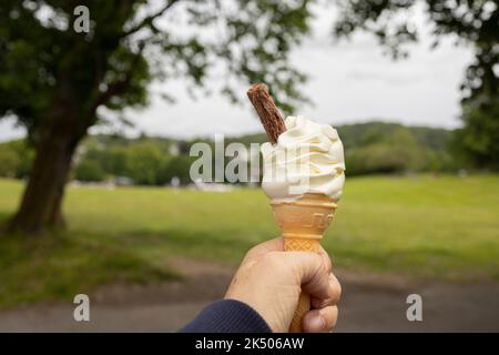 Ice cream cone held up to the hot summer sky with chocolate treat Stock Photo