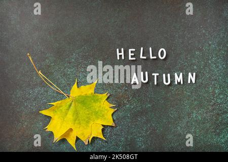 Hello Autumn text. Autumn composition with colorful leaves. Cozy autumn mood. Fall seasons greeting card. Stock Photo