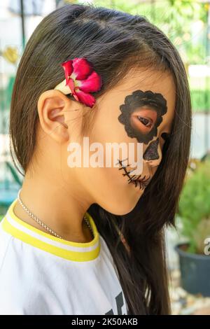 Close up the attractive girl in the sugar skull makeup. Day of The Dead. Halloween. Stock Photo