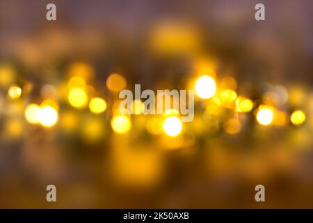 Blurred lights of bulbs on dark background. Defocused. Christmas, New Year, holiday Stock Photo