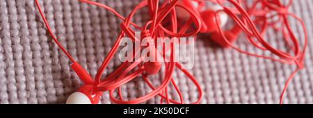 Tangled red headphones on gray background. Headphone mess Stock Photo