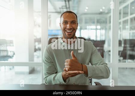 African businessman using sign language while talking online with client sitting in office Stock Photo