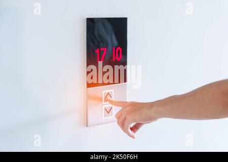 Hand finger press the Elevator button, woman waiting for Elevator in office or apartment Stock Photo
