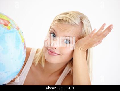I dont know where it is on the map. A pretty young woman at a loss as to where to travel next for a holiday. Stock Photo