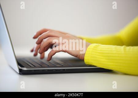 Woman typing text on computer keyboard. Young female working on laptop in the office. Copy writer person works on modern notebook pc at home Stock Photo