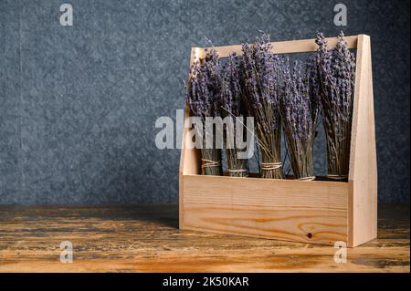 Composition of dried lavender flowers in a wooden basket on dark background Stock Photo