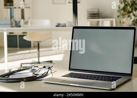 Close-up of laptop with empty screen on workplace of doctor at office Stock Photo