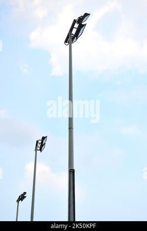 Tall sport stadium light stanchion or light tower from low angle in bright sunshine or daytime. Stock Photo