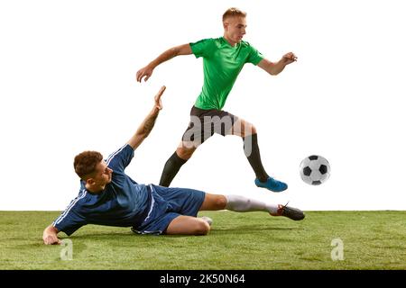 Soccer football players tackling for the ball on grass flooring over white background. Concept of sport, action, competition, football match Stock Photo