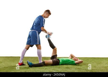 Foot injury. Rival soccer players in action, motion isolated over white background. Sport, competition, communication and match concept. Stock Photo