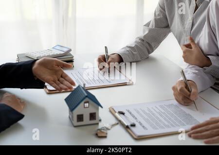 Real estate agent with couple closing a deal and signing a contract. Stock Photo