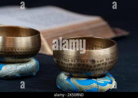 A closeup of Tibetan bells and an old spiritual book Stock Photo - Alamy