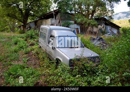 Rusty Old Car Wreck or Derelict Car Renault Express Van in Abandoned Farm Yard Stock Photo