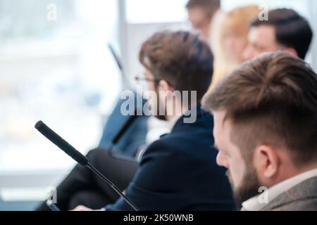 Focused businessmen sitting in conference hall during presentation Stock Photo