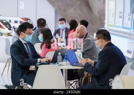 Entrepreneurs working at tables in modern hall Stock Photo
