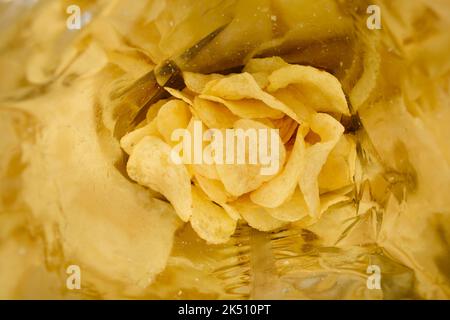 Crispy potato chips with salt inside foil bag package Stock Photo
