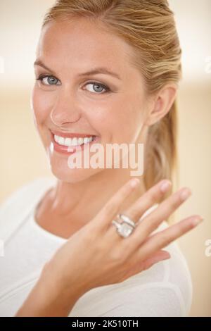 He finally popped the question. Portrait of an attractive young woman showing off her engagement ring. Stock Photo