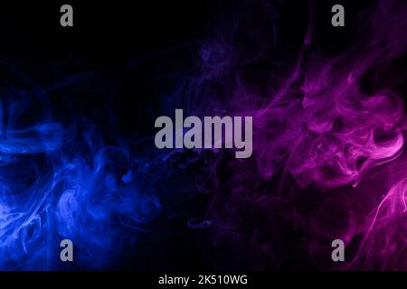 Flowing clouds of colorful swirling blue and pink smoke dark abstract background Stock Photo