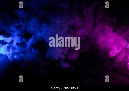 Clouds of colorful swirling blue and pink smoke dark abstract background Stock Photo