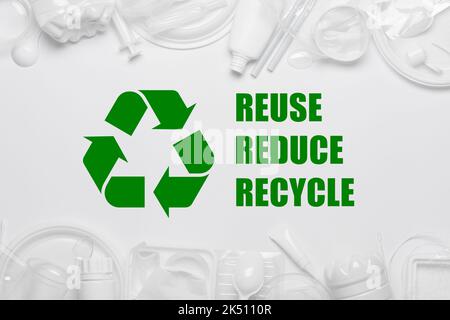 Recycling sybmol with reuse reduce recycle slogan surrounded by single-use plastic objects, packaging plastic products Stock Photo