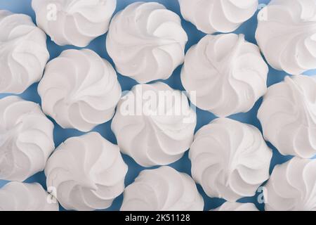 White meringue cookies on blue background top view Stock Photo