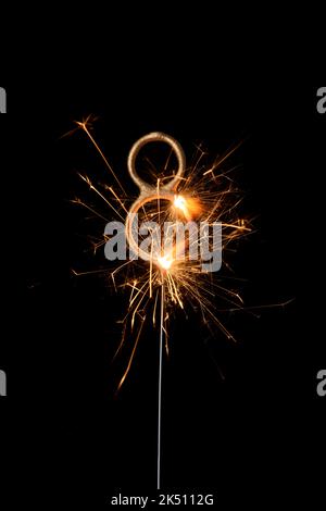 Burning golden sparkler in shape of number eight, digit 8, isolated on black background Stock Photo