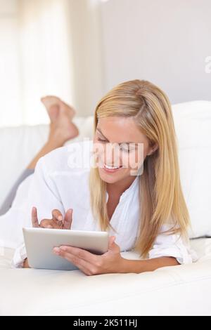 Keeping an online journal. A beautiful young blonde woman working on her digital touchpad. Stock Photo