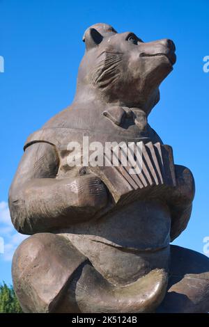 A bronze sculpture of a happy bear, playing a small accordian. In the plaza in front of the Circus arena building in Astana, NurSultan, Kazakhstan. Stock Photo