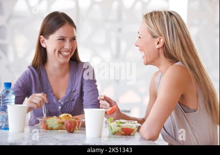 Lets just enjoy our lunch. two colleagues having lunch together. Stock Photo