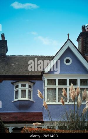 Lilac Cottage Against Blue Sky Stock Photo