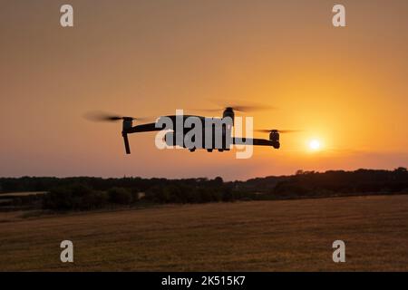 Mavic DJI drone flying at sunset Stock Photo
