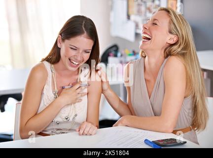 Getting along great with her business partner. Two designers laughing during a meeting. Stock Photo