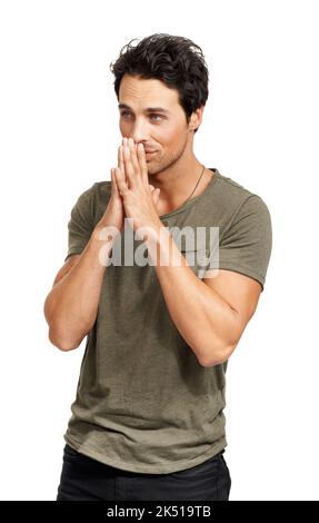 Please let me win the Lottery. A handsome young man standing with his hands together in a hopeful gesture. Stock Photo