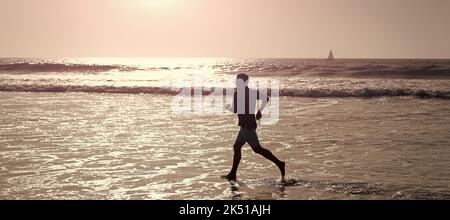 Man running and jumping, banner with copy space. athletic man runner silhouette run on summer beach with sea water and sun, endurance. Stock Photo