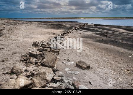 The remains of an old Cornish Hedge wall exposed by falling water levels caused by severe drought conditions at Colliford Lake Reservoir on Bodmin Moo Stock Photo